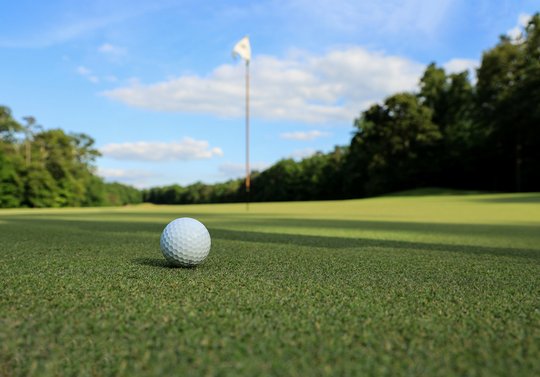 Golfball liegt auf Rasen